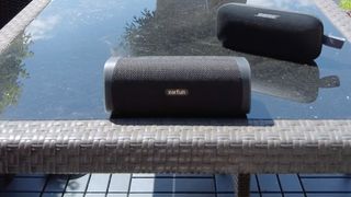 Earfun UBoom L speaker on a table, with Bose Soundlink Flex in the background