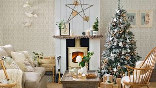 cozy neutal living room with log burner fire and snowy Christmas tree to create a hygge Christmas part theme