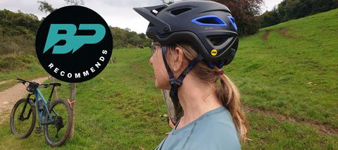 female mountain biker in the countryside wearing a black Giro Montara helmet