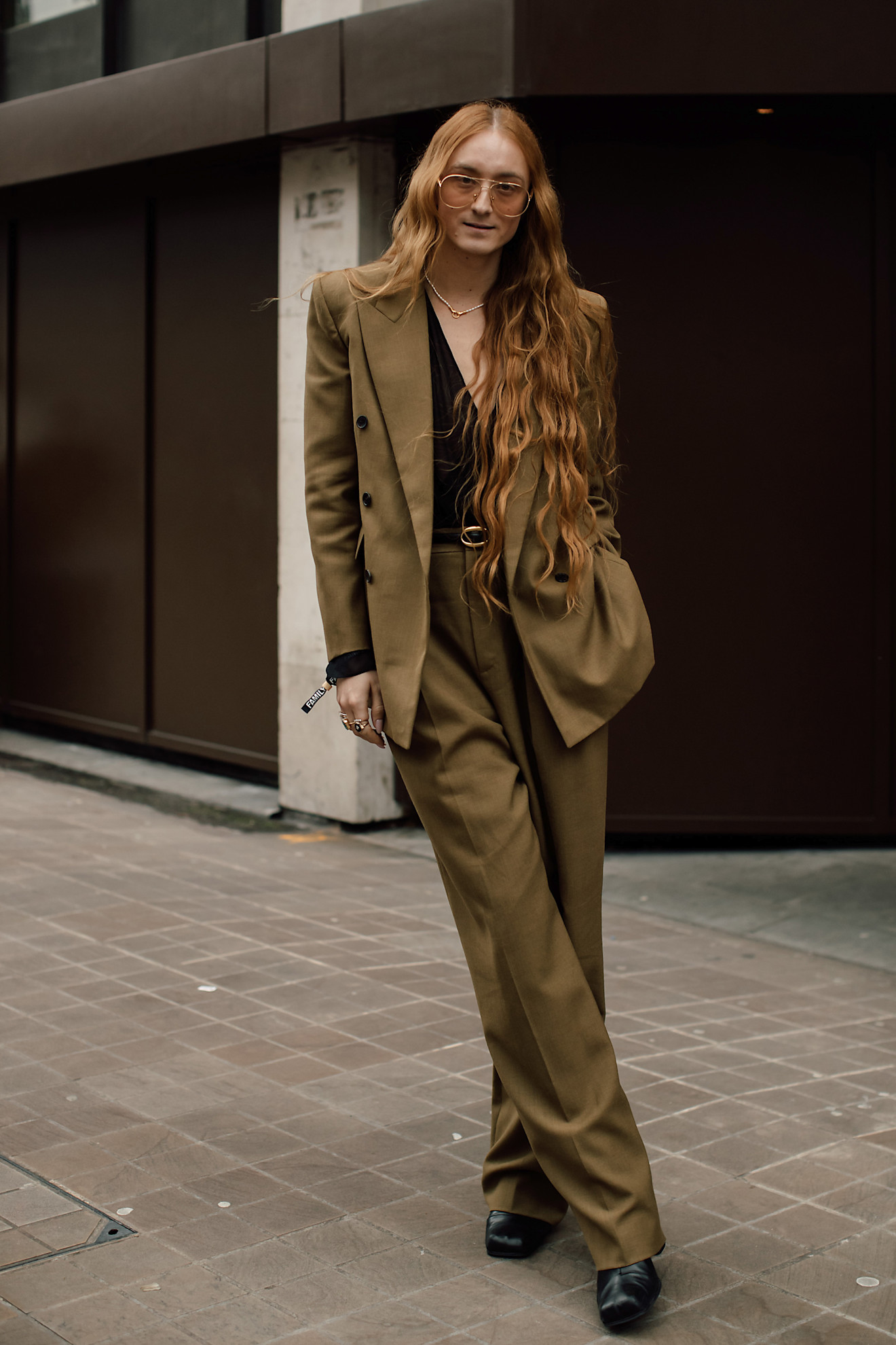 a woman with a tan suit and long wavy red hair