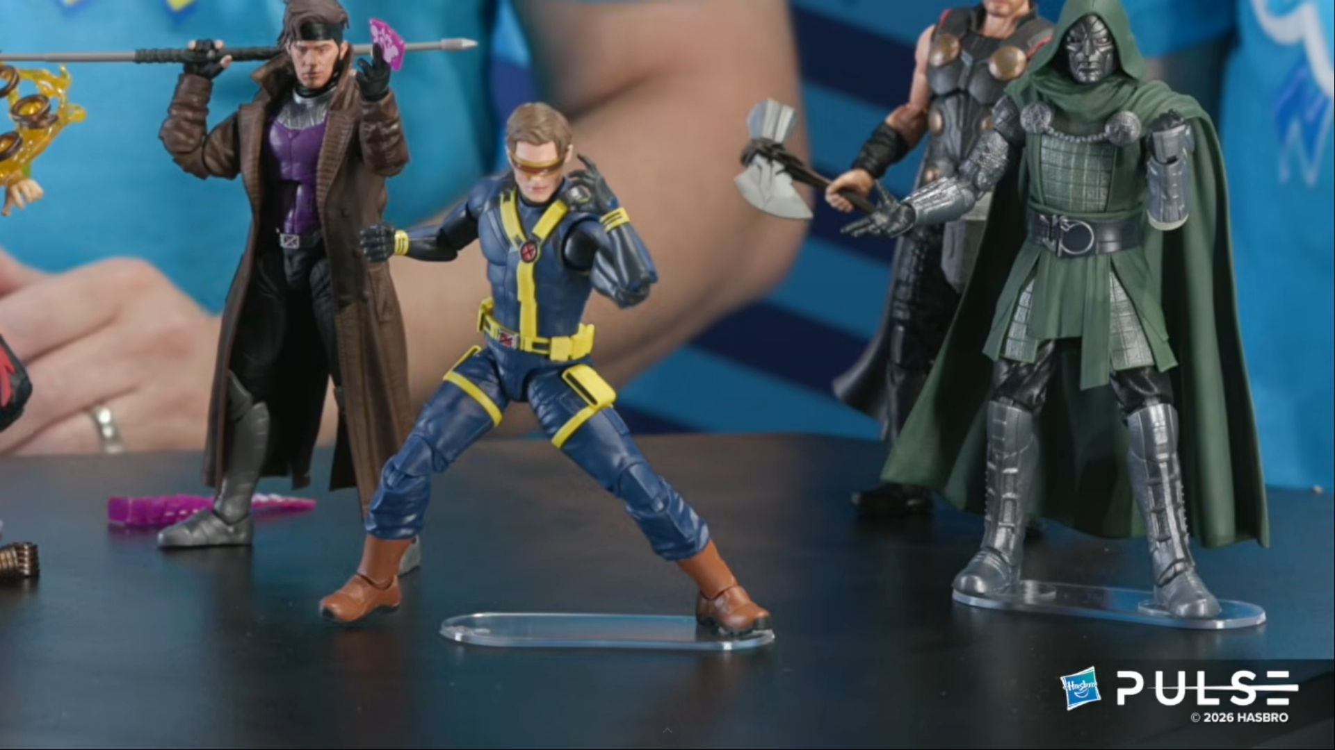 Doomsday action figures for Gambit, Cyclops, Thor, and Doctor Doom posed on a black surface
