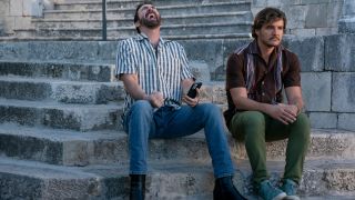 Nicholas Cage laughs while Pedro Pascal sulks on the steps in The Unbearable Weight of Massive Talent.