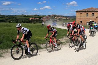 Team Qhubeka Assos rider Switzerlands Mauro Schmid L rides on a gravel section in a breakaway group during the eleventh stage of the Giro dItalia 2021 cycling race 162 km between Perugia and Montalcino on May 19 2021 Photo by Luca BETTINI AFP Photo by LUCA BETTINIAFP via Getty Images