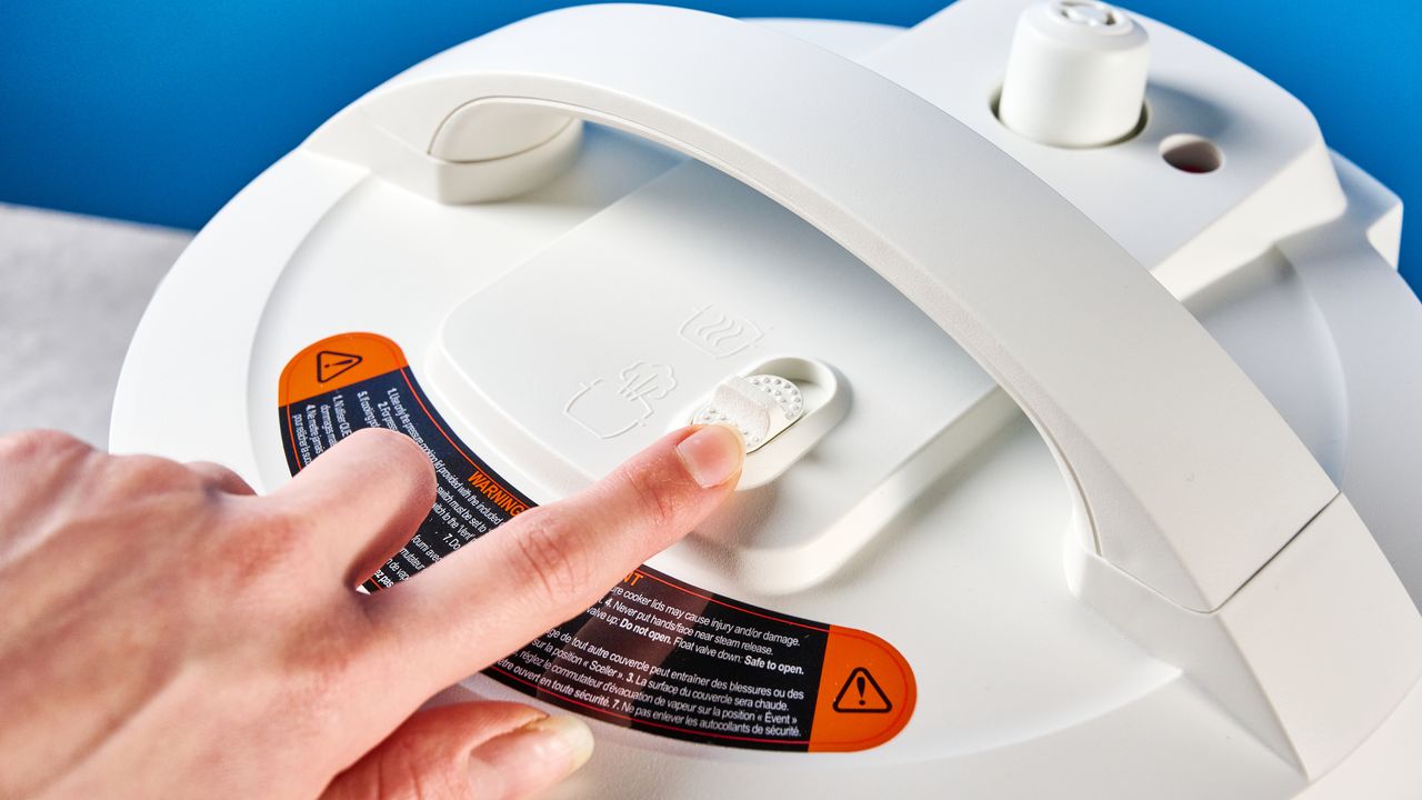 the instant pot rio mini / instant pot mini in white photographed against the blue tom's guide background showing its inner pot, accessories, and cooking programs