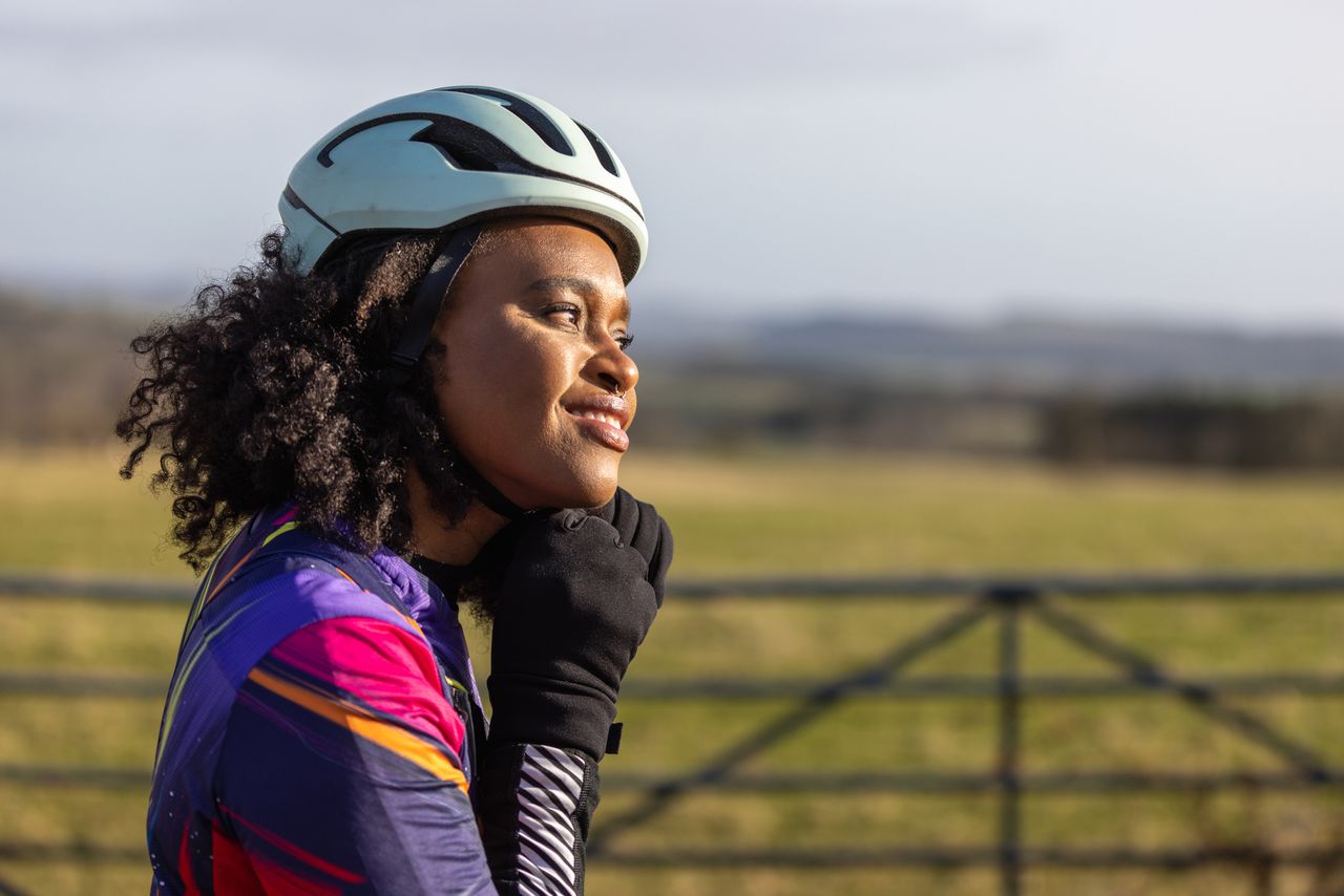 Female cyclist fastens a helmet 