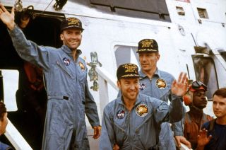 Apollo 13 astronauts Jim Lovell (at center), Fred Haise (at left) and Jack Swigert on the deck of the USS Iowa Jima aircraft carrier after splashing down from the ill-fated moon mission and being recovered by helicopter on April 17, 1970.