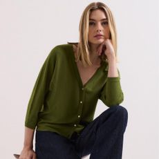 Young woman wearing green Phase Eight blouse and blue denim jeans