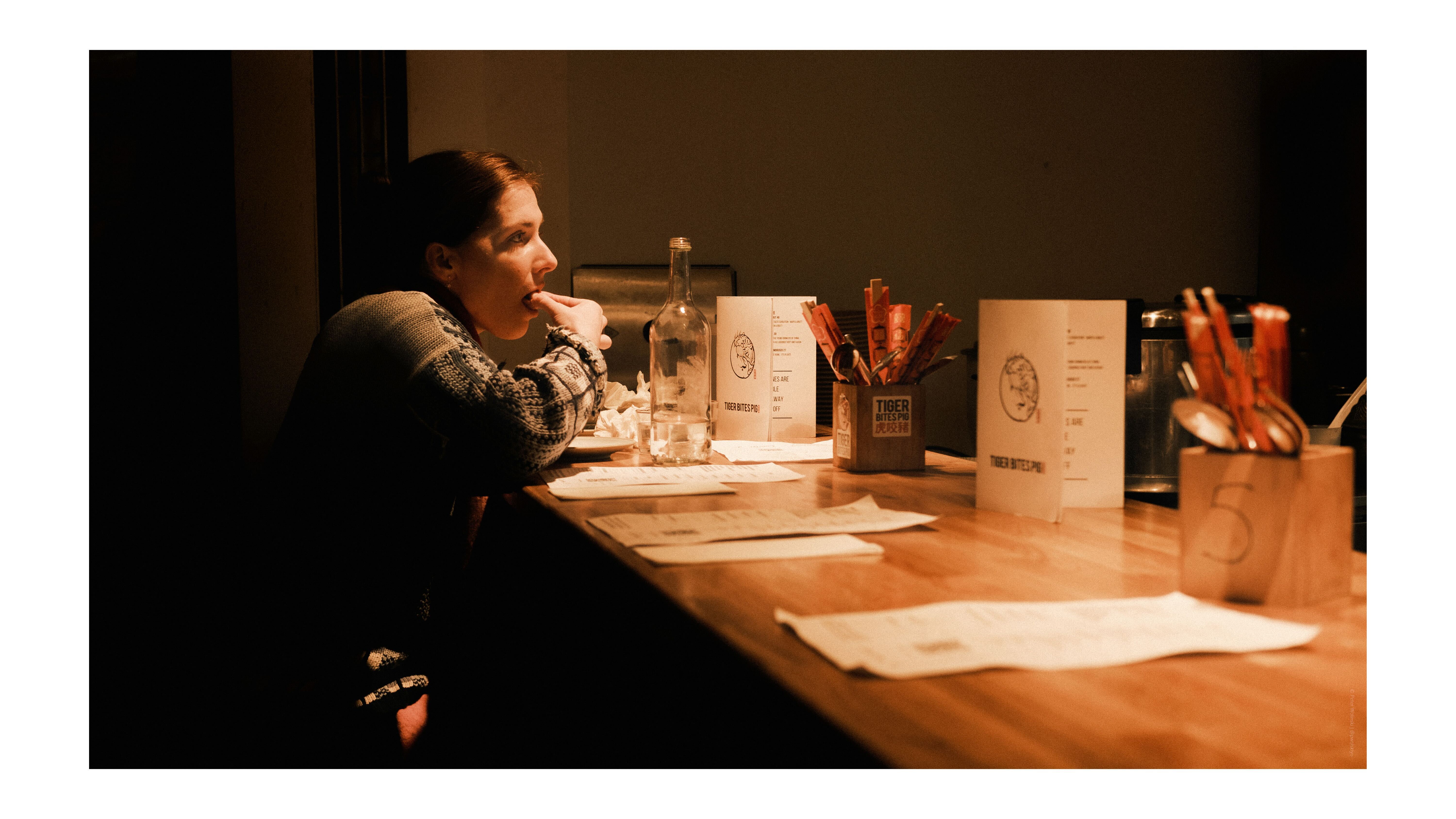 A photo of a woman eating bao buns in a restaurant