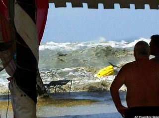In this photo taken by a tourist Eric Skitzi from England, tourists watch as tsunami waves hit the shore from a safe place inside Casuarina Beach Hotel resort in Penang, northwestern Malaysia around 1:00pm in local time (0500GMT) Sunday, Dec. 26, 2004. The resort hotel lifeguards noticed waves were huge and sounded warning to all tourists around the hotel beach area to run to the safety area. The Malaysian government on Wednesday canceled New Year celebrations nationwide, urging people to pray this weekend that the country will be spared from future disasters such as the recent tsunamis that killed at least 65 Malaysians.