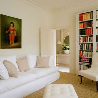 room with white sofa door and open book shelve