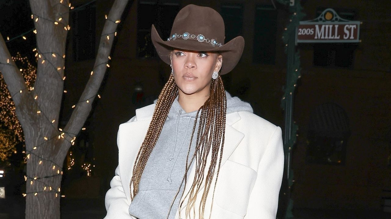 Rihanna wearing a western hat with a sweatshirt and a blazer