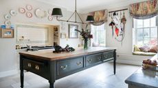 A green freestanding kitchen island takes pride of place in a country kitchen