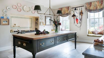 A green freestanding kitchen island takes pride of place in a country kitchen