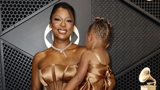Victoria Monét is holding her daughter, Hazel, on the Grammys red carpet.
