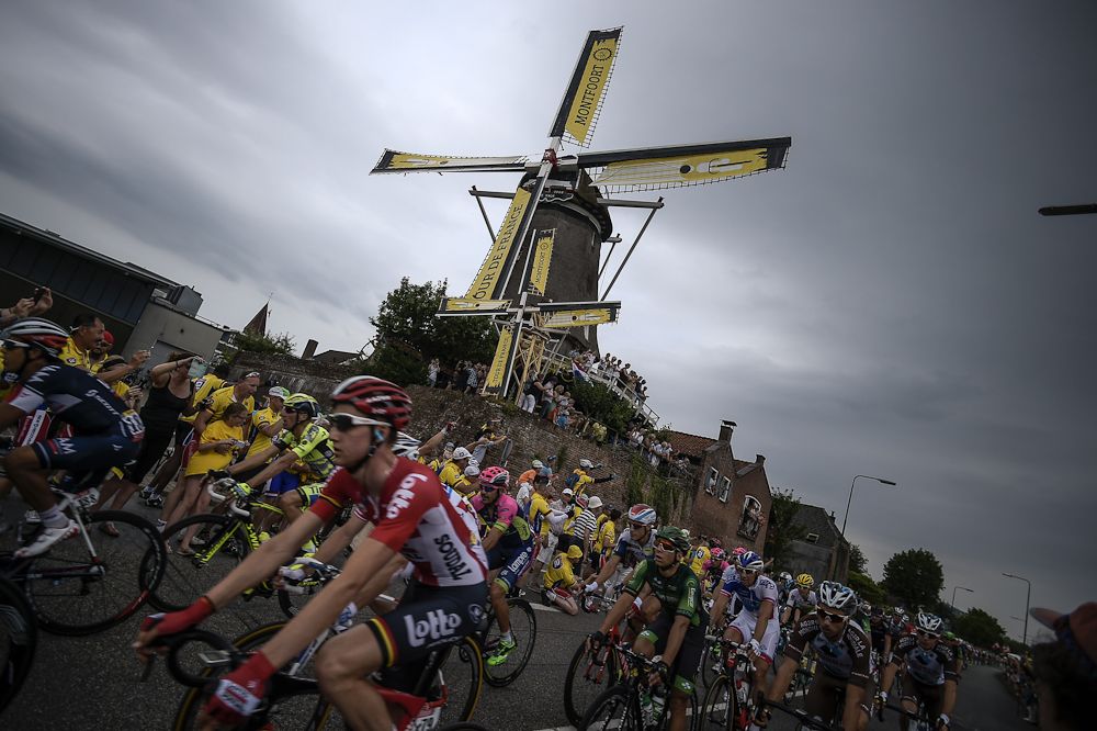 The peloton rides past a windmill during stage 2.