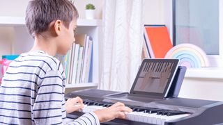 Kid playing keyboard with help from learning app