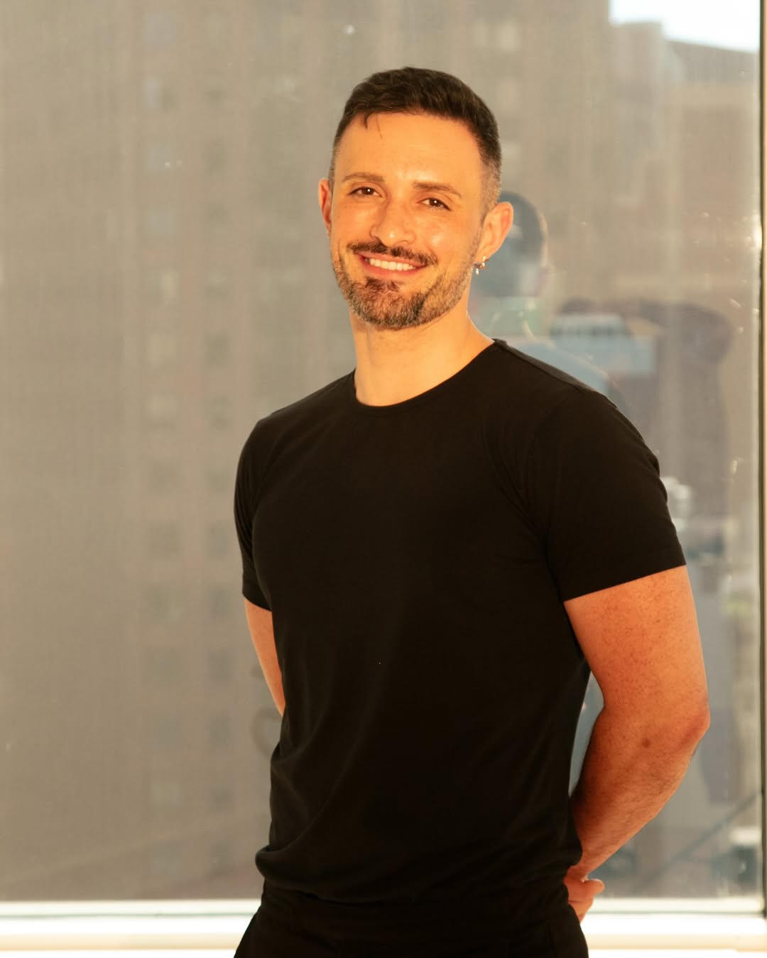 a person wearing a black shirt and smiling at the camera