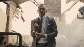 Daniel Craig as James Bond adjusting his cuff after jumping into a ripped-open train car in Skyfall