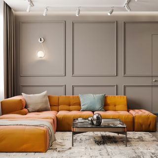 Grey painted living with panel moulding feature wall effect, yellow sofa with cushions