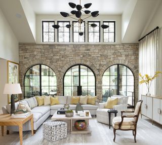 living room with vaulted ceiling, three arches, L-shaped sofa, black pendant light