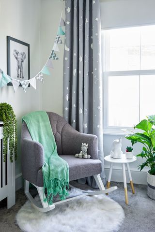 Dani Dyer nursery corner with rocking hair, side table and fake plant