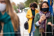 Woman in face mask looking at phone