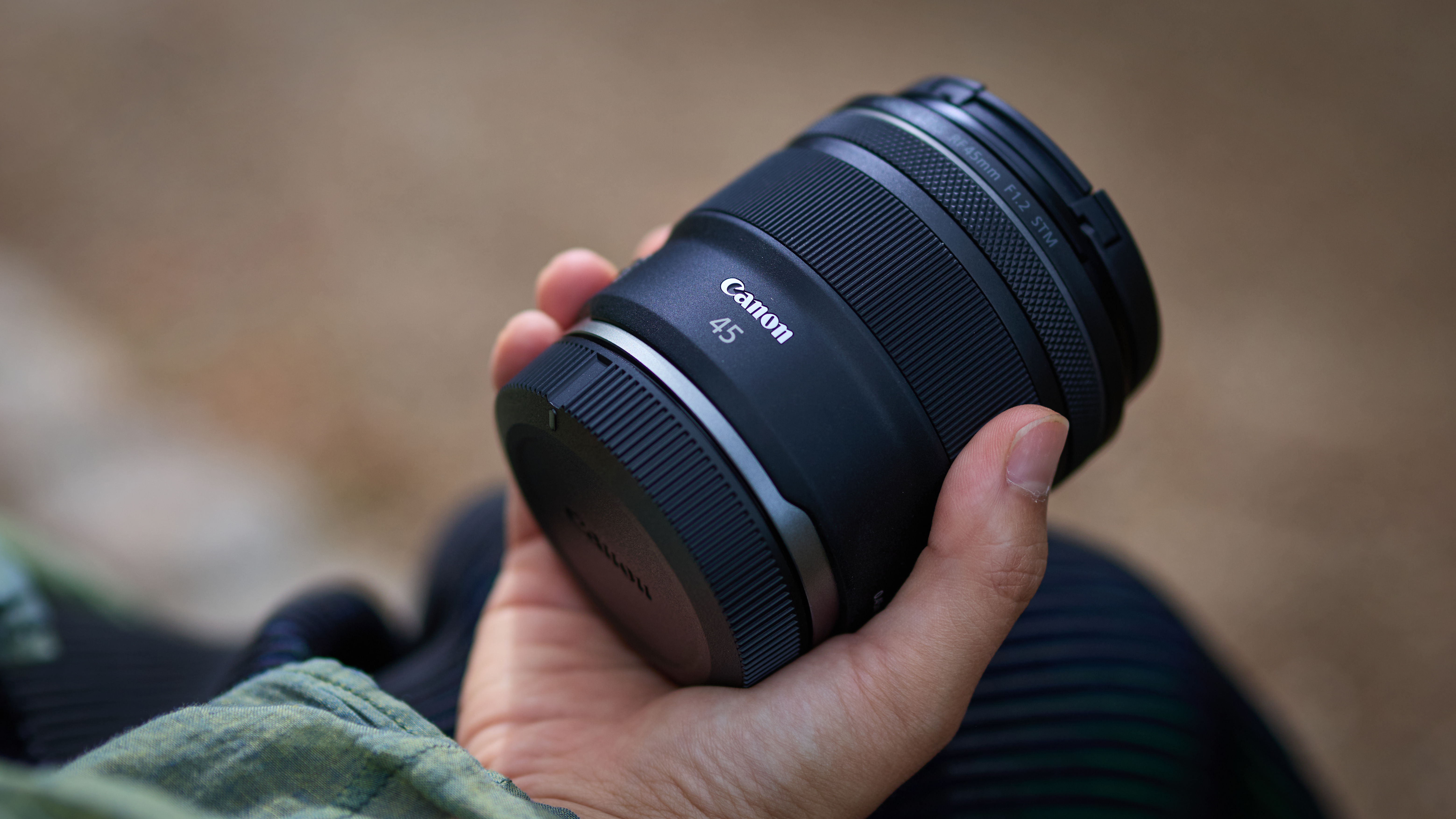 Canon RF 45mm f/1.2 STM being held by a photographer