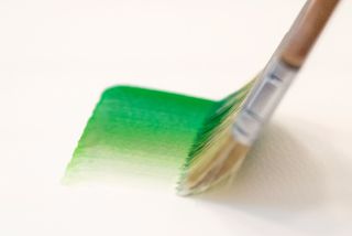 A brush with a green stroke of paint