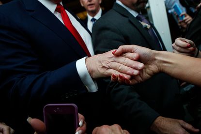 Donald Trump shakes hands with a supporter