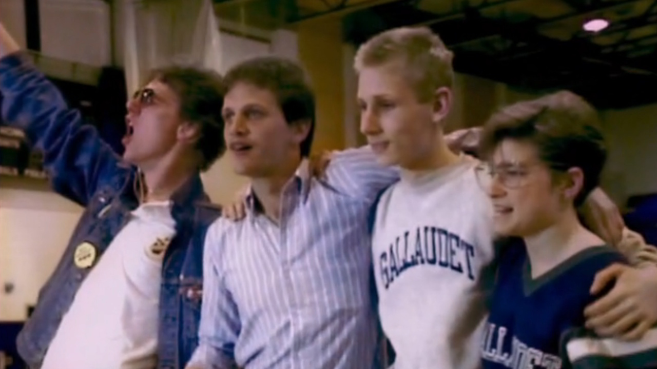 左から右へ、ジェリー・コベル、ティム・ラルス、グレッグ・フリボク、ブリジッタ・ボーン＝フィル。1988年にギャローデット大学で行われたデフ・プレジデント・ナウの抗議活動中に写っている。