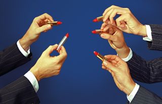 Five male hands holding a red lipstick.