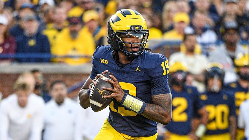 Bryce Underwood of the Michigan Wolverines preparing to throw the ball downfield during a college football game.