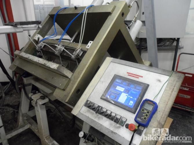 The mould is loaded into this computer-controlled cage, where the resin is injected and three vacumn pumps draw out the air and pull the resin through the structure