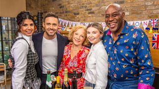 Ruby Bhogal, Spencer Matthews, Jilly Goolden, Georgia Toffolo and Ainsley Harriott in front of a table of drinks in Ainsley's Coronation Kitchen.