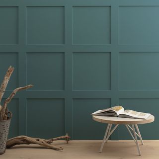 teal wall with small round side table