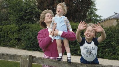 Princes William and Harry with their mother, Diana, Princess of Wales (1961 - 1997) in the garden of Highgrove House in Gloucestershire, 18th July 1986. William is wearing a Dallas Cowboys t-shirt.