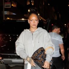Rihanna wears gray sweats paired with a sold-out Louis Vuitton emblem bag covered in velvet and sequins