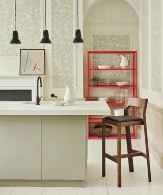 Multifunction breakfast bar with white kitchen island, wainscotting on wall, beaded paneling with wallpaper inside, red shelving unit, bar stool, trio of black pendant lights, white painted floorboards