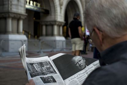 A man reads an article by The New York Times on President Trump.