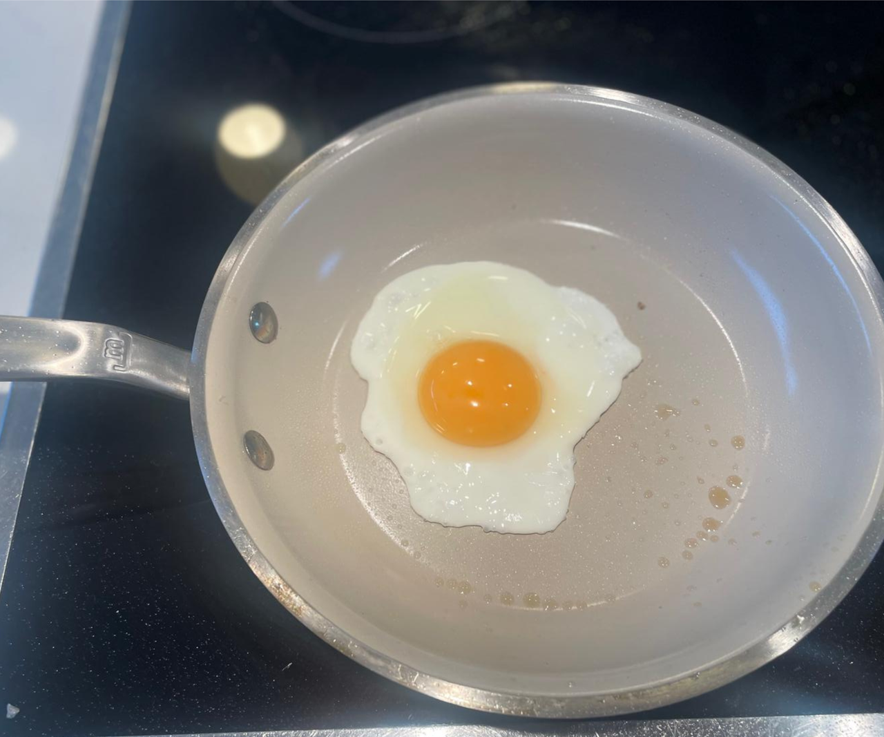 A sunny-side-up egg frying in a Made In CeramiClad&trade; Non-Stick Frying Pan