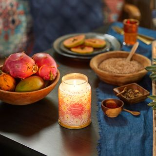 yankee candle on wooden table with fruits
