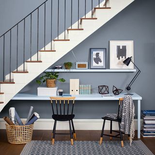 grey wall with stairs and frames and chairs