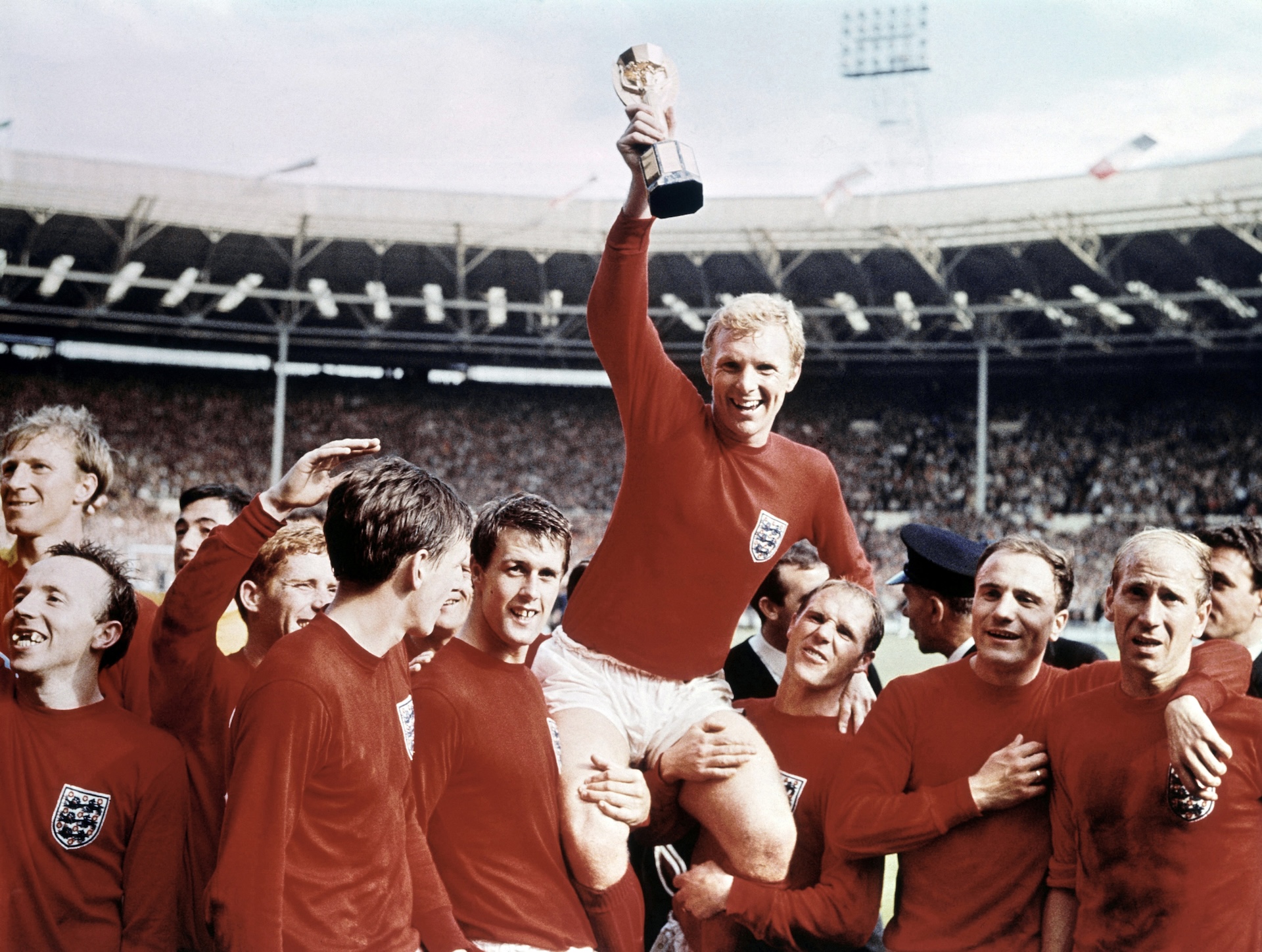 World Cup Final at Wembley Stadium, England versus West Germany. Captain Bobby Moore holds aloft the Jules Rimet trophy as he sits on the shoulders of his teammates.