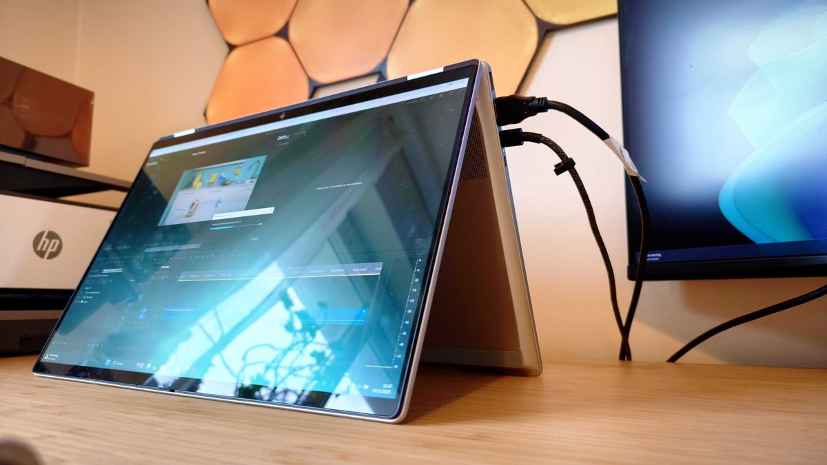 Silver HP Omnibook X Flip 16 2-in-1 laptop on a wooden desk