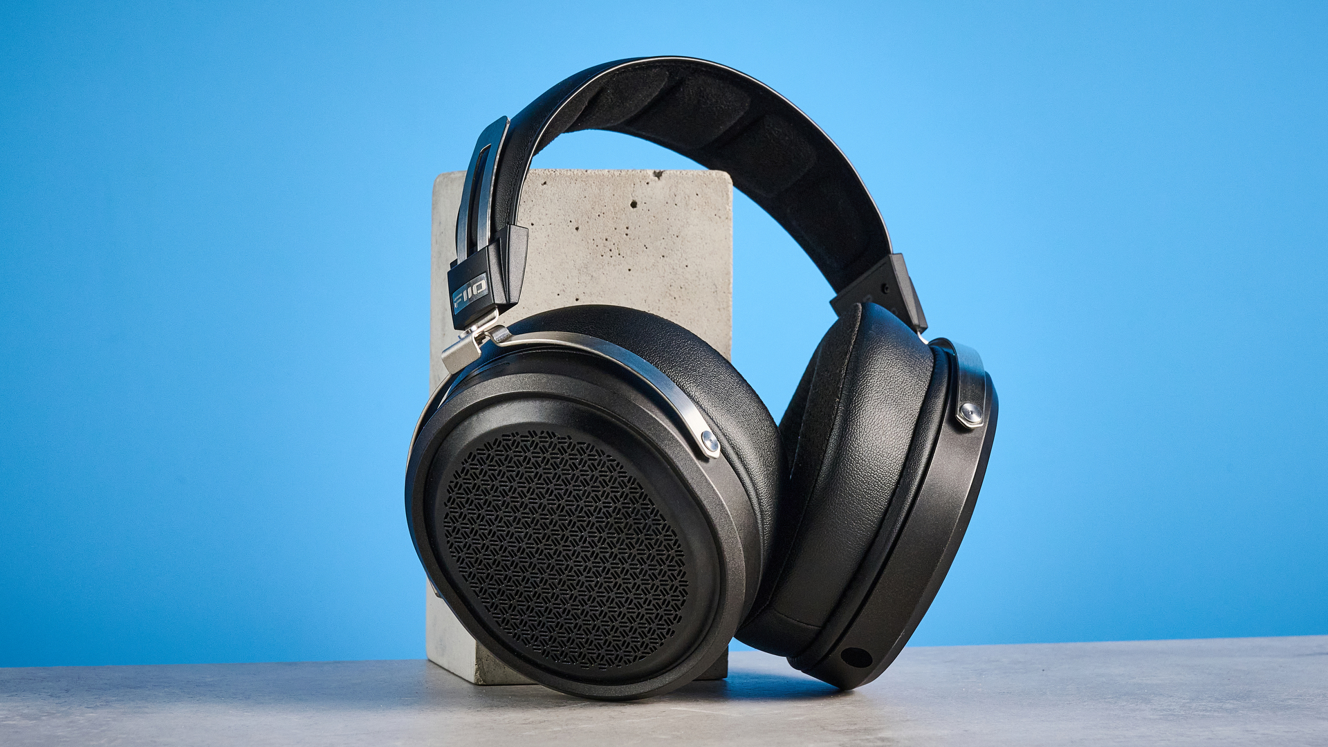 the fiio ft1 pro wired open-back headphones photographed with a blue tom's guide background