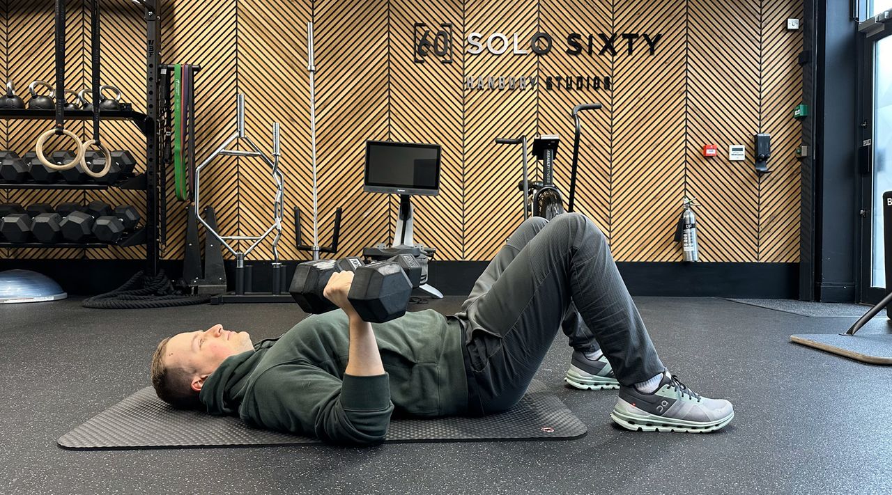 Ollie Thompson beginning a dumbbell floor press