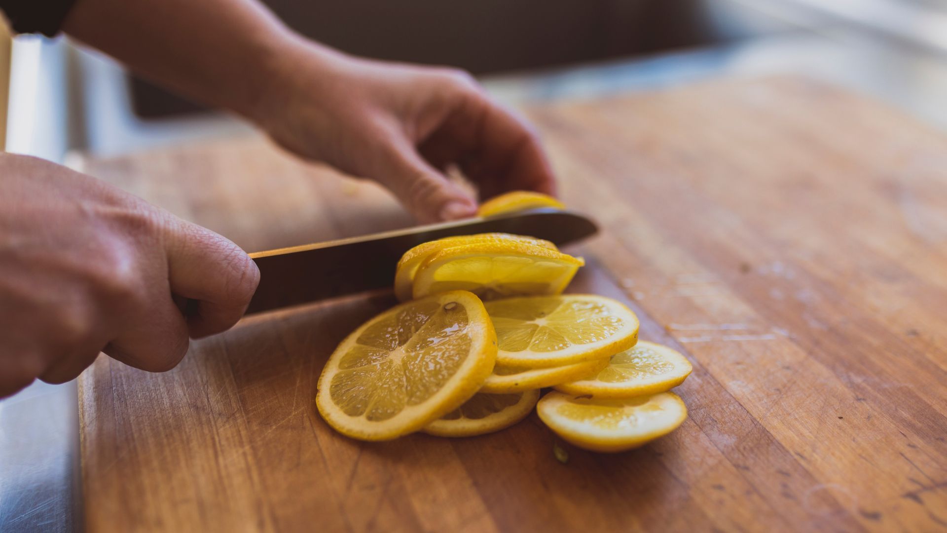 Person slicing a lemon to try the TikTok viral pillow cleaning hack experts are puzzled by