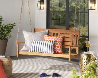 Front porch idea by Wayfair with wooden swing seating idea and assortment of cushions
