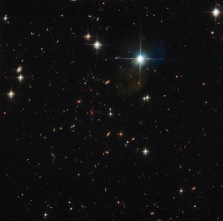 The galaxy cluster SPT0615 paints a stunning visage across the constellation Pictor (The Painter) in this dazzling view from the Hubble Space Telescope released May 10, 2019 by the European Space Agency.