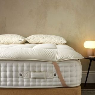 A Woolroom mattress topper on top of a mattress